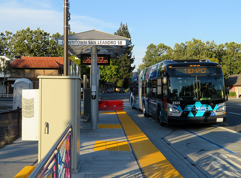 A bus station with one bus stopped in downtown San Leandro, California.
