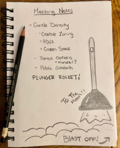 a sketchbook lies folded open with a pencil on top. A pencil list that reads “Meeting notes: Gentle Density, Creative Zoning, ADUs, Green Space, Transit Options, Monorail, Public Outreach, Plunger Rocket!” occupies most of the page. In the lower right corner, a sketched rocket ship that looks like a toilet plunger blasts off, with fire coming from under the plunger dome. License: Cc by SA 4.0_MassLandlords Inc