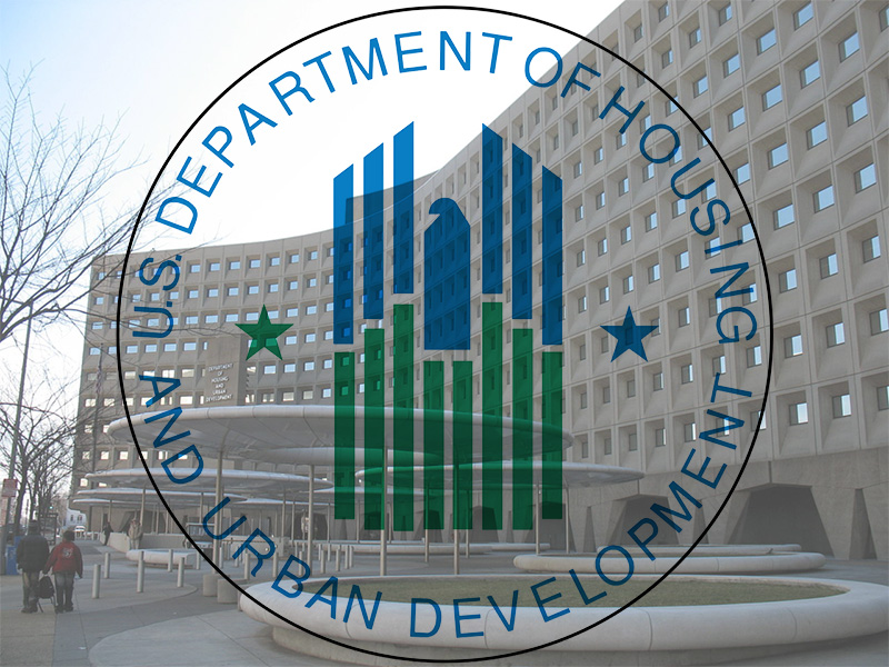 This image is the logo for the U.S. Department of Housing and Urban Development superimposed over a photograph of the HUD headquarters. The logo is a round image on a white background done in shades of light blue and green. The center is a blue and green abstract urban skyline with an eagle’s head in profile in the center and two stars offsetting it. The department’s name is spelled out in a border that surrounds the image. The headquarters building is a multistory gray office building