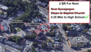 an overhead view of a densely settled neighborhood, with homes, a school and two houses of worship. The houses of worship and school are labeled by Google Earth. One house is circled in red. A text box reads “2 Bedroom for Rent” and has “Near Synagogue” and “Steps to Baptist Church” crossed off in red. The sentence “0.25 mile to high school” has a green check mark beside it.