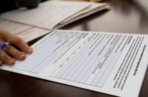 Image of a hand with a pen on top of MassLandlords Rental Application