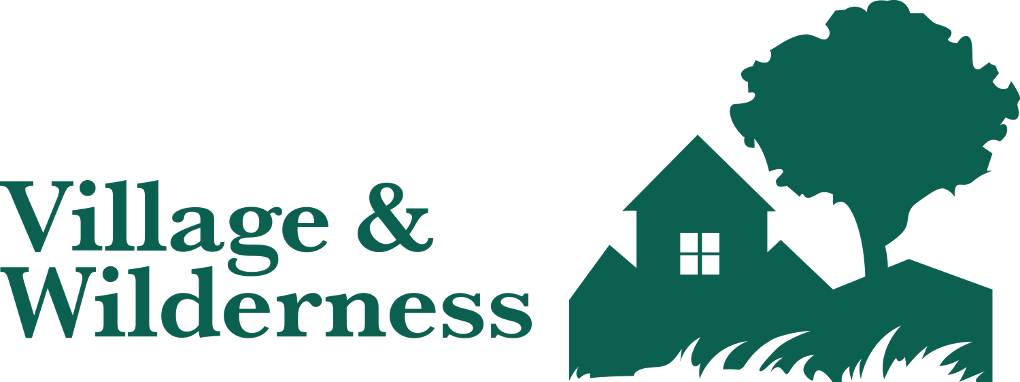 The Village and Wilderness logo features a house beside a tree sitting on windswept grass.