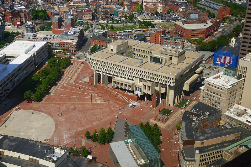alt: View of City Hall Plaza from One Beacon Street. Faneuil Hall, at upper right, has an American flag covering construction scaffolding. CC BY-SA 4.0 NewtonCourt.