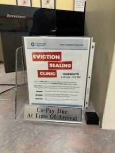 A sign on the check-in desk at a UMass Memorial healthcare provider's office advertised eviction sealing in early May 2025.