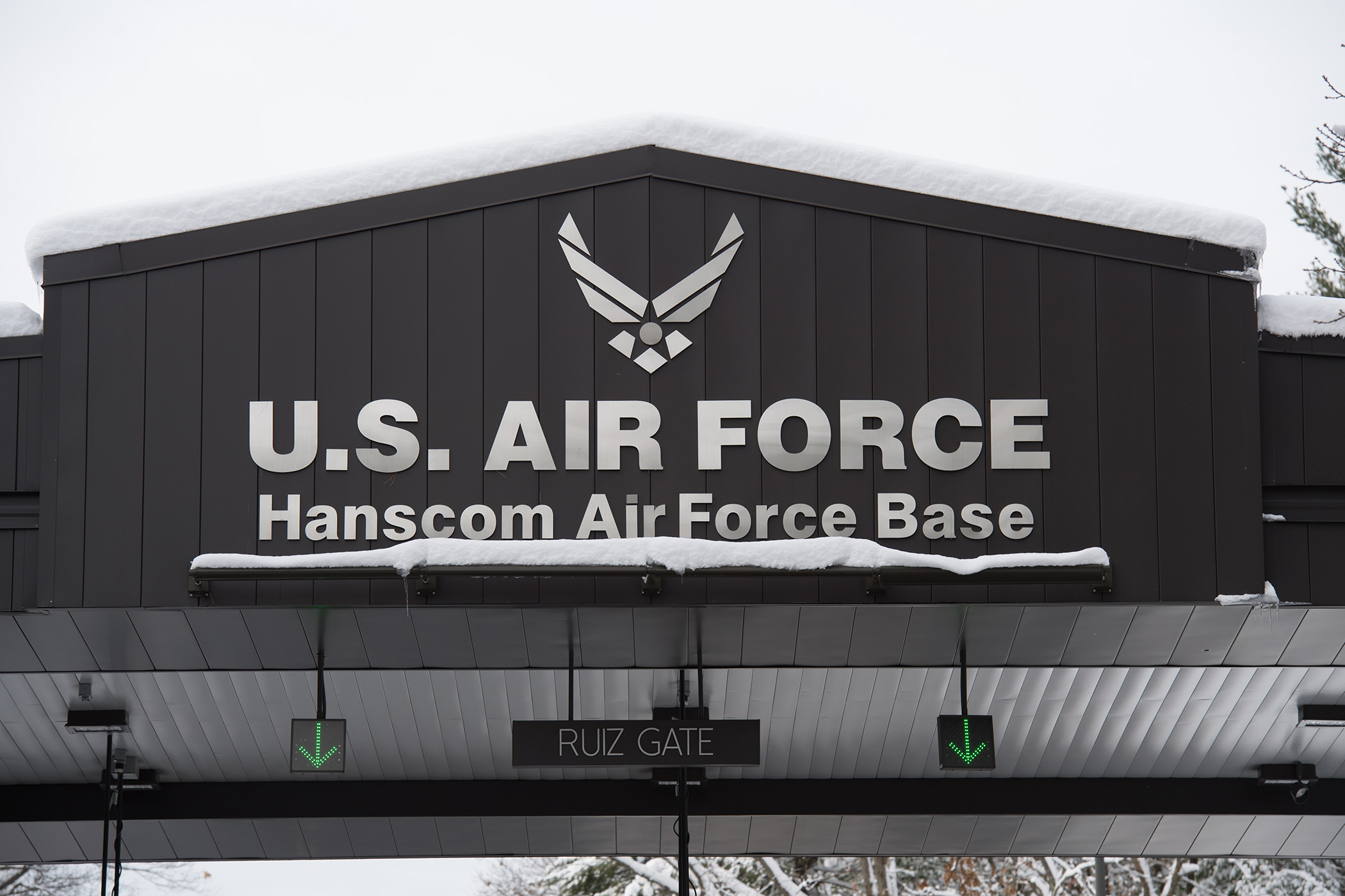 A photograph of the top of a gated entrance to Hanscom Air Force Base in Massachusetts. It reads “U.S. Air Force, Hanscom Air Force Base, Ruiz Entrance.”
