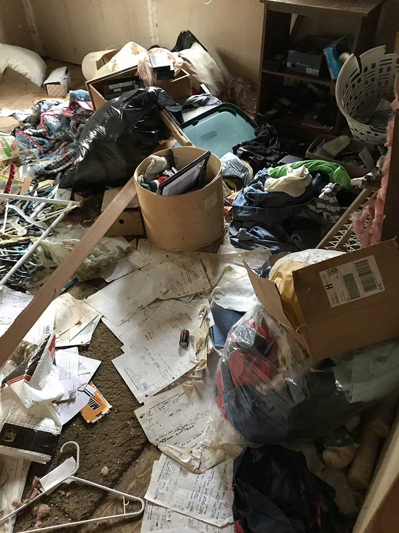 another room with a floor covered in clutter, trash and boxes