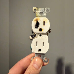 An outlet held up shows complete melting on one side.