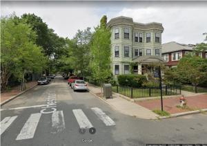 Google Maps screenshot of the intersection of Chestnut and Magazine streets in Cambridge. A three story house with two columns of large bay windows sits on the corner. A tall sign declares this intersection Peter and Helen Petrillo Square.