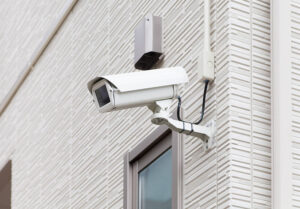 closeup photo of a security camera mounted on the exterior of a building.