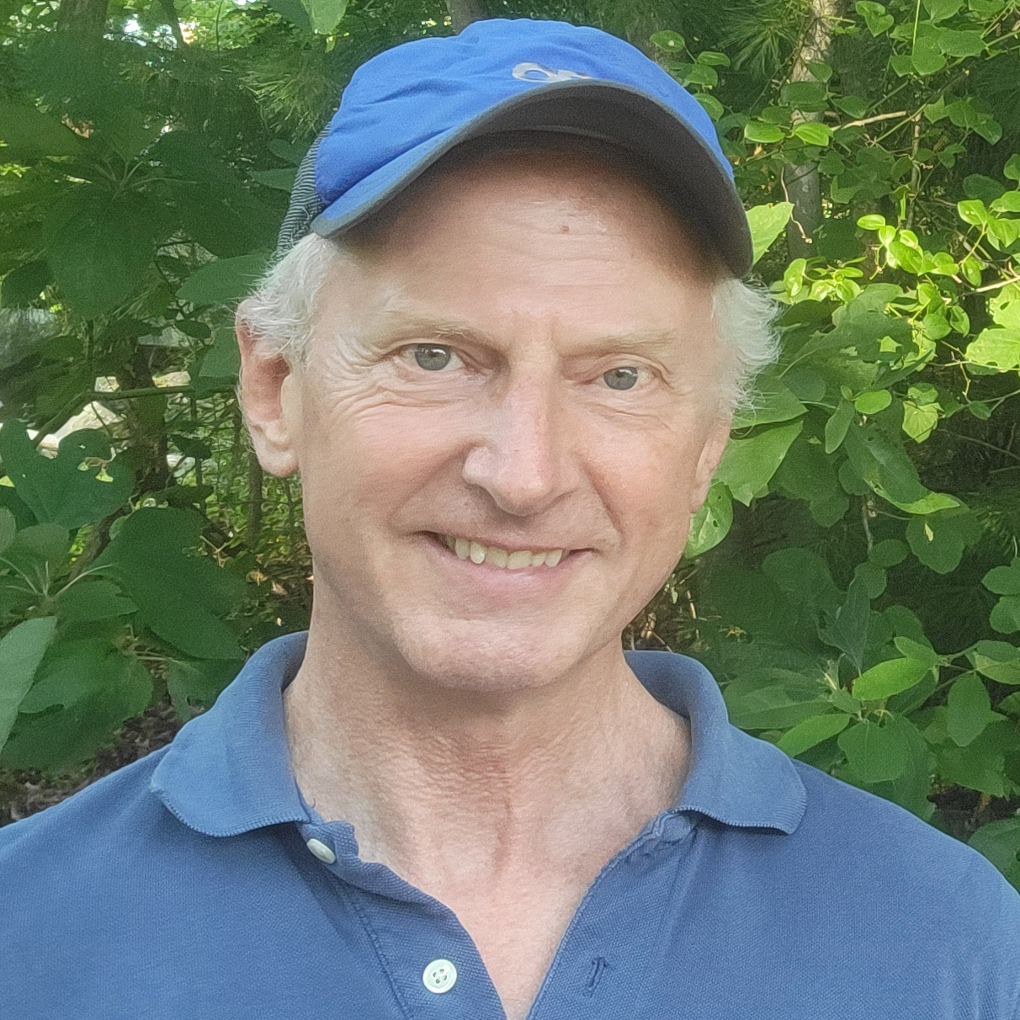 picture of Eric Weld smiling. He wears a collared shirt and suit jacket
