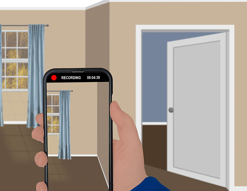 This is a cartoon image of an empty room in an apartment with beige walls and hardwood floors. A window is in the distance. A door on the right side of the room is ajar, revealing an empty room with blue walls. In the foreground, a hand holds a phone up with the camera app open, recording a tour of the empty room.