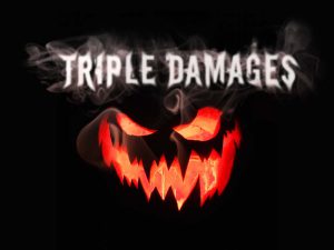 A carved jack-o-lantern against a black background is lit from within by a candle that makes its face glow orange. The pumpkin has a scary expression, with narrowed eyes and an open mouth full of pointy teeth. Above the pumpkin, the words “Triple Damages” in a creepy font appear in white, with white smoke surrounding them.