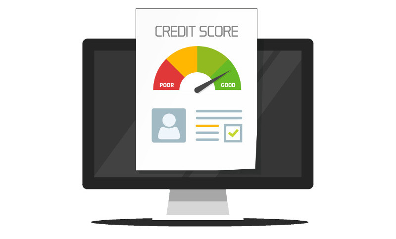 A computer screen is behind a credit report showing a needle gage pointing to the "Good" section of a credit score range from bad to good. Licensed 123rf.