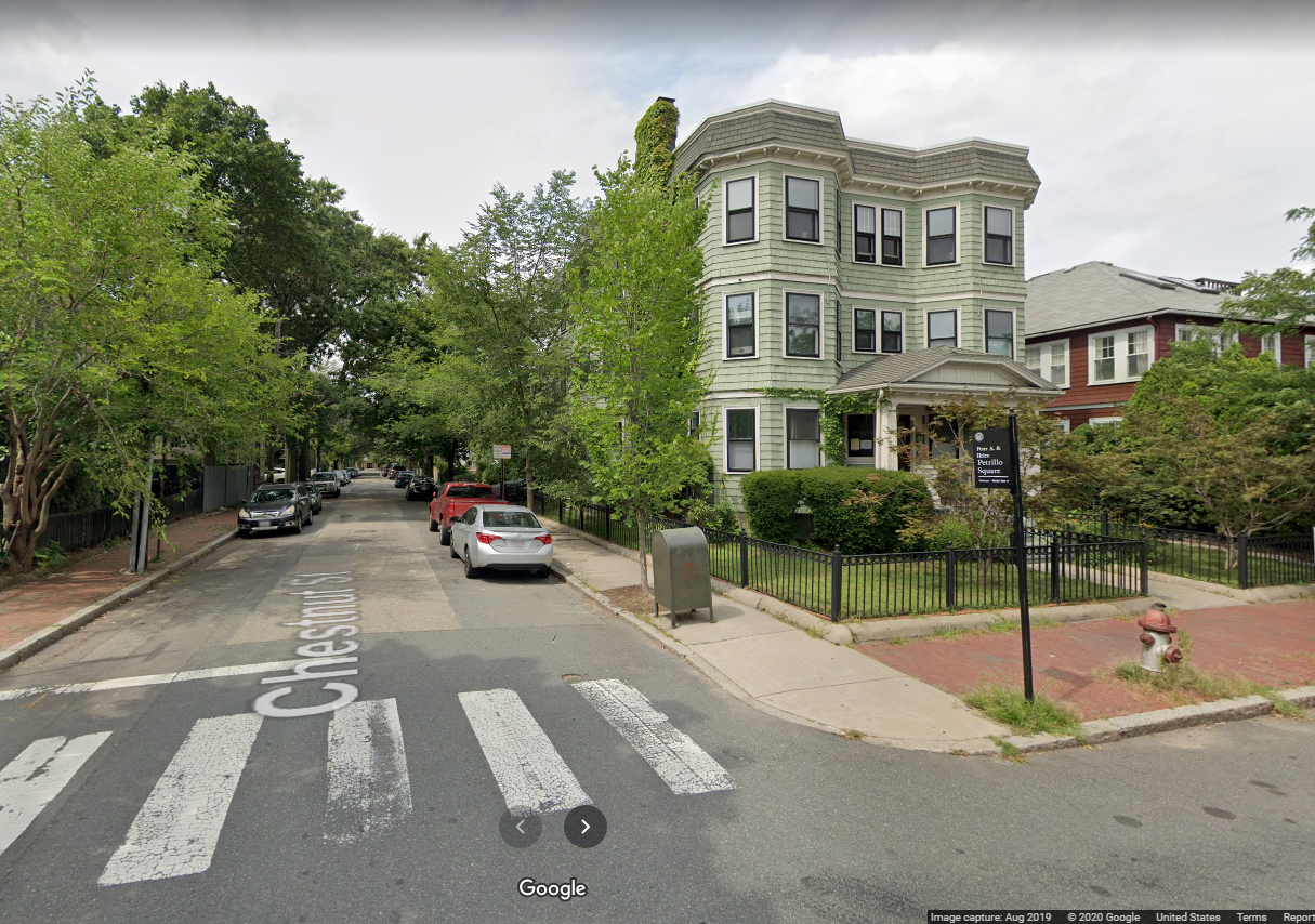 A google maps view of Petrillo Square. A three decker with apparently six units (two vertical stacks of bay windows letting in warm sun) face the marker put in place to honor Peter Petrillo. The street address is Magazine and Chestnut, Cambridge, MA.