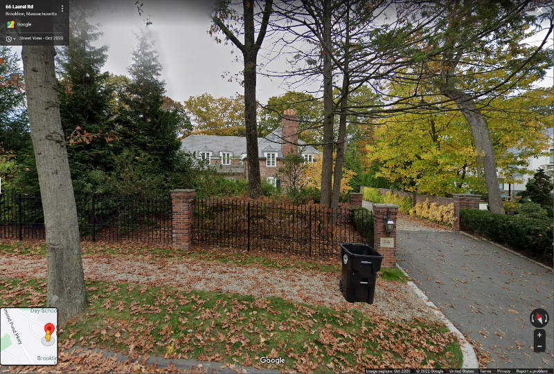 The street view of 66 Laurel Dr, Brookline shows a masonry and wrought iron gate leading to cobblestone driveway and brick mansion beyond. Oak leaves litter the ground in fall.